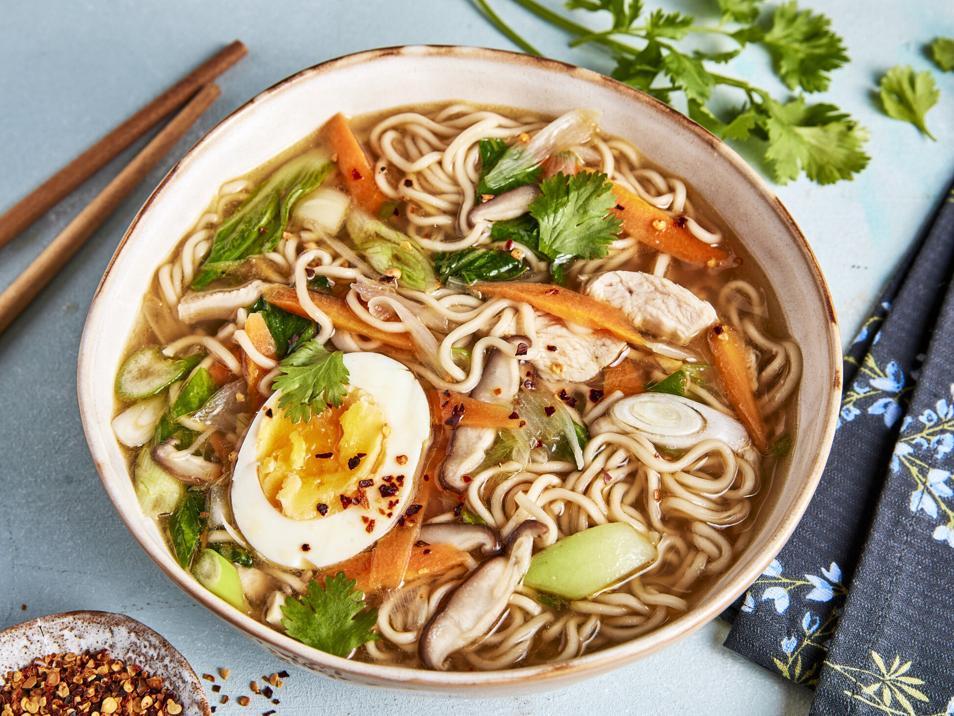 A bowl of ramen noodles with rich broth, chashu pork and toppings